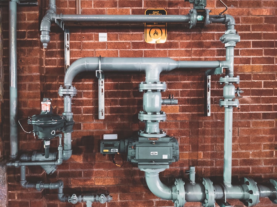 Exposed metal plumbing pipes and valves on a brick wall