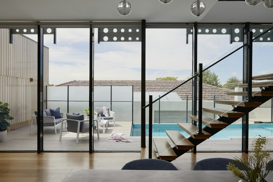 Large glass windows and sliding doors opening to a patio